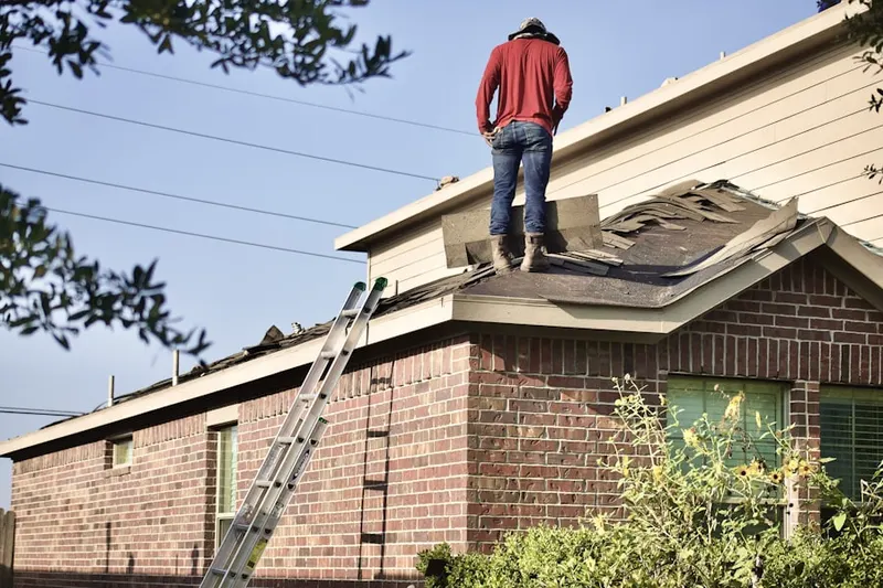 Professional roofer working on a residential roof in Marcy